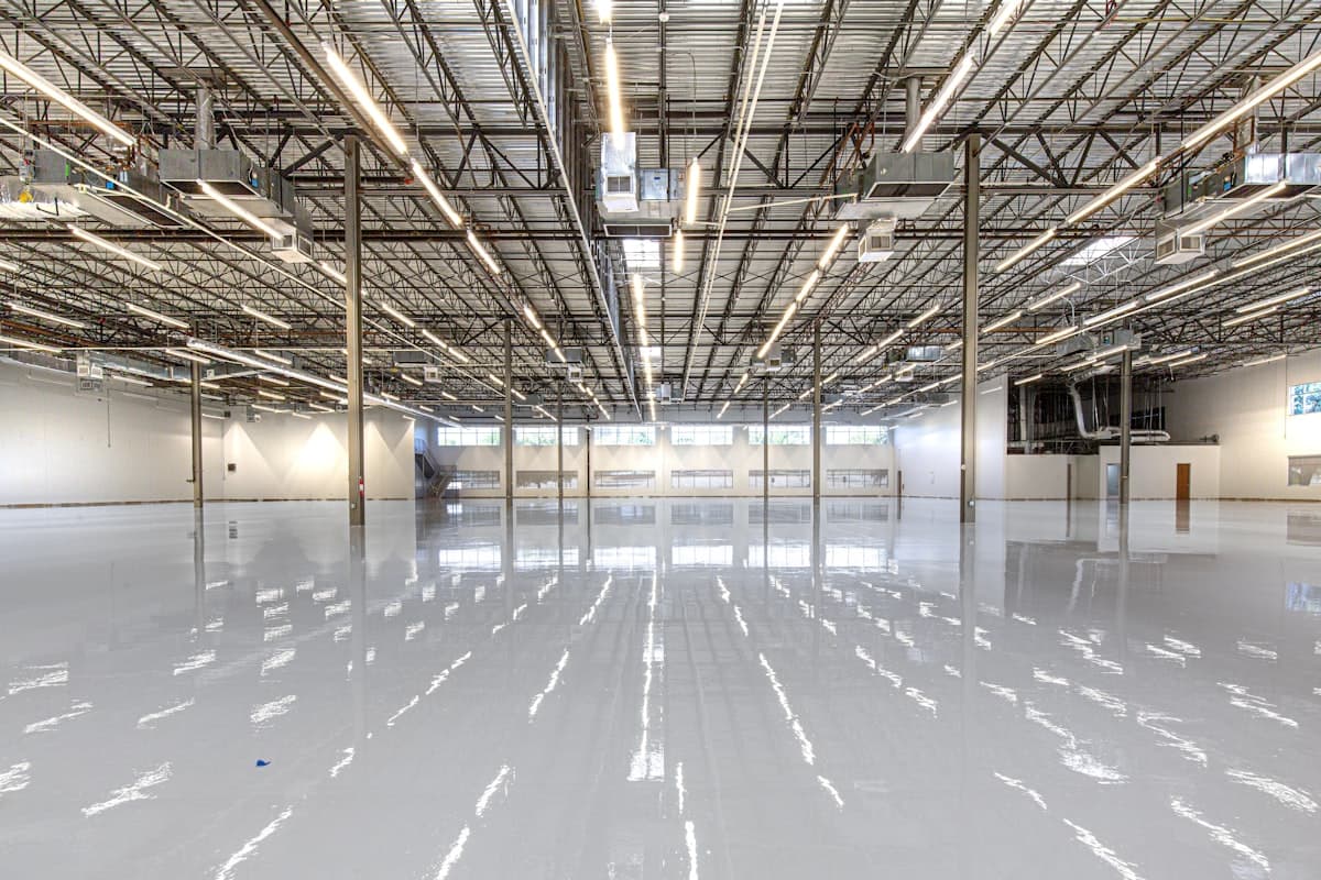 Foto de referencia: bodega industrial con piso epóxico brillante y señalización de tránsito